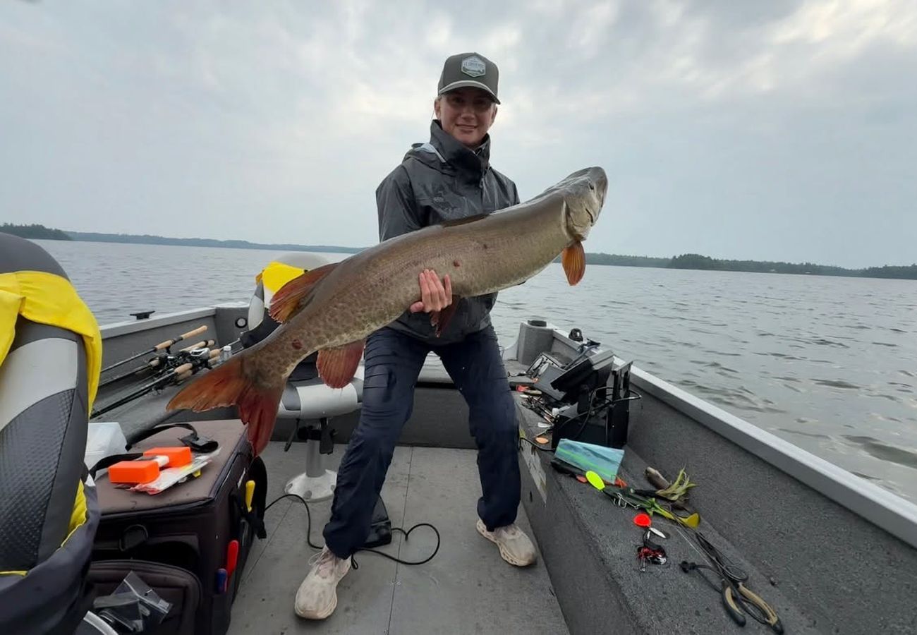 Angler in the boat with a huge rainy-day muskie