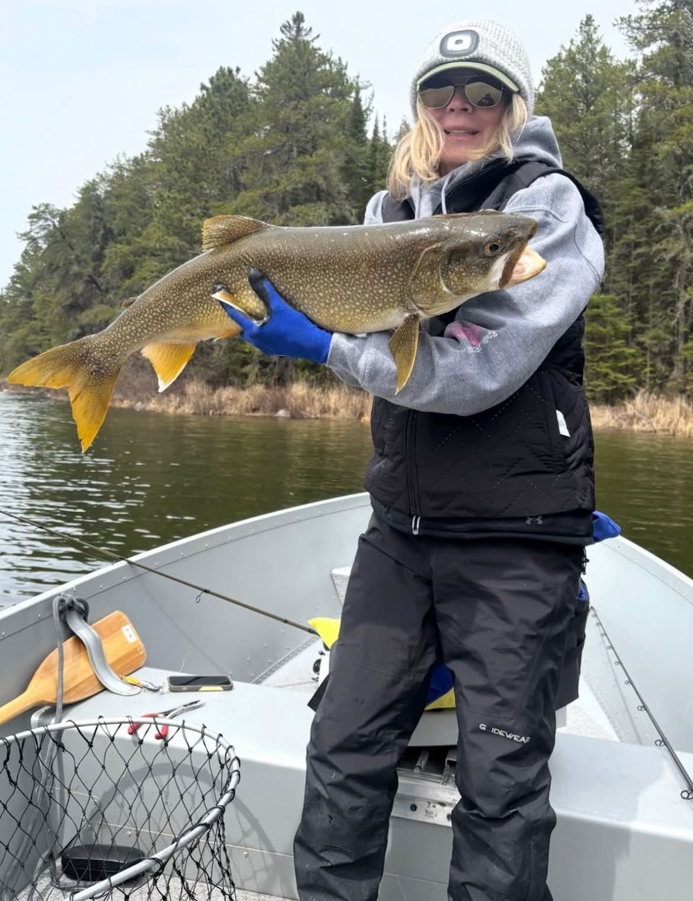 Angler in the boat holding a golden walleye