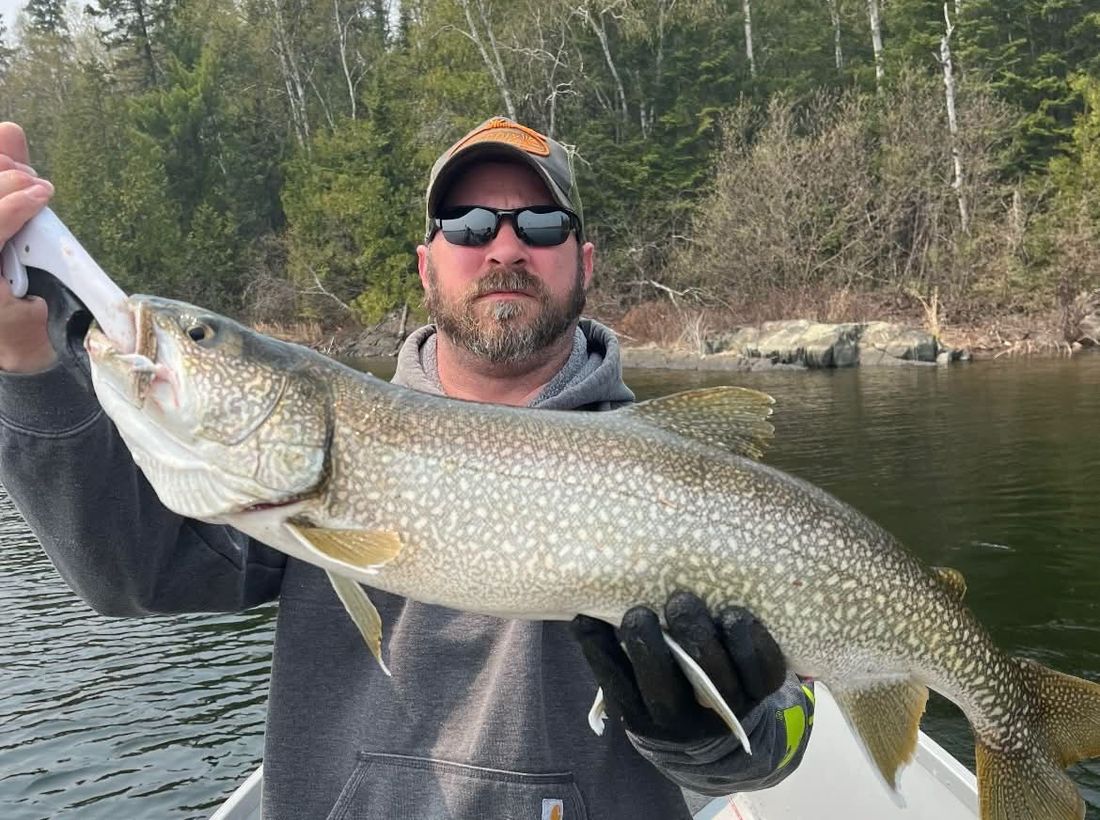 Angler holding a trophy lake trout caught at Wilderness Fishing Oasis