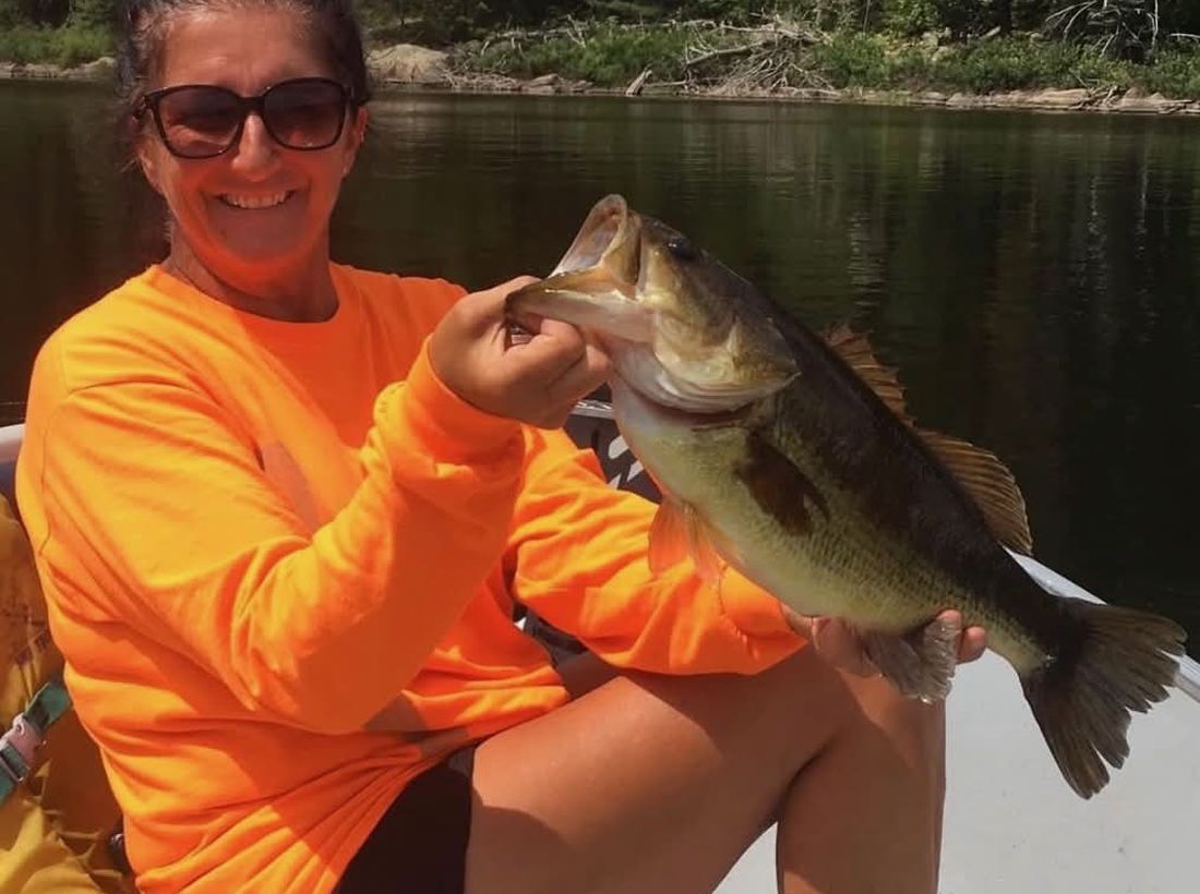 Angler holding a largemouth bass caught at Wilderness Fishing Oasis