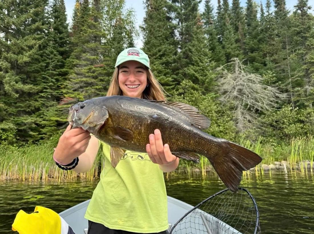 Young angler holding a big smallmouth bass caught at Wilderness Fishing Oasis